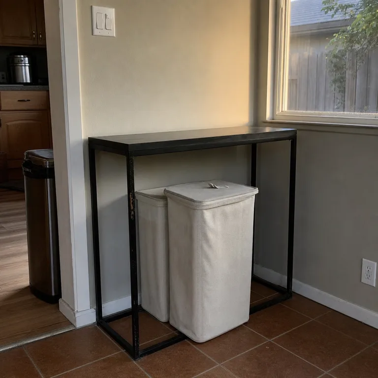 Two lidded sorting bins stored under a narrow console table on a kitchen wall.