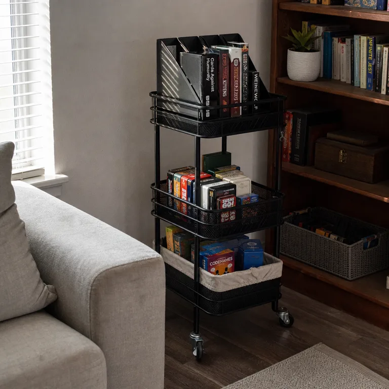 Rolling cart storing card games and small board games beside a living room bookcase.