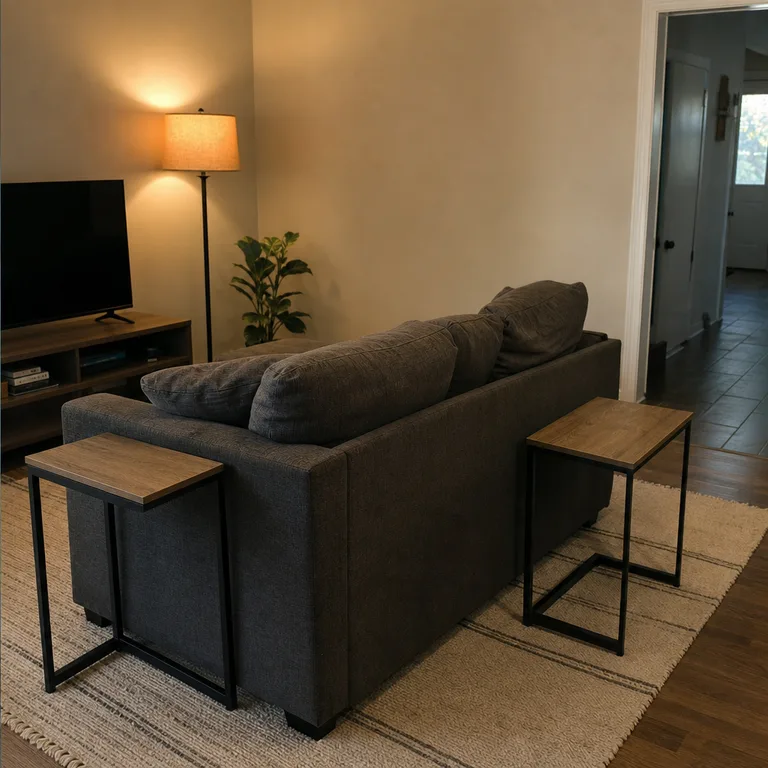 Slim C-tables beside sofa seats holding cards, snacks, and game supplies.