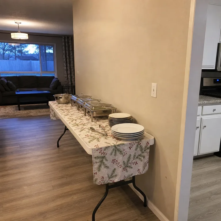 A folding table placed against a living room wall creates a contained buffet with an open central traffic path.