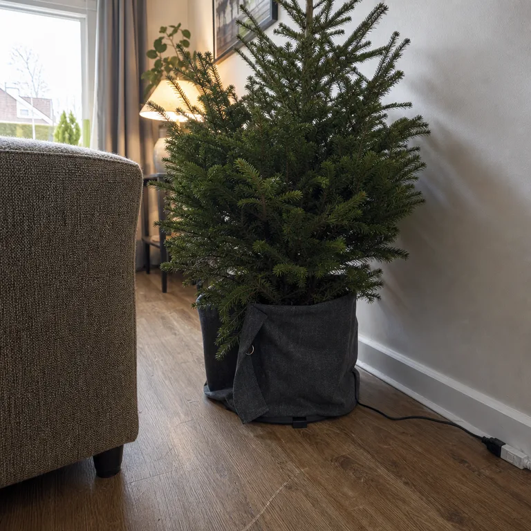 A charcoal fabric wrap fastened around a plastic tree stand with the cord kept outside.
