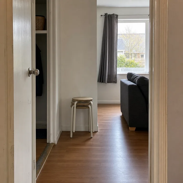 A stack of compact stools taken from a hall closet and set out as temporary guest seating in a small living room.