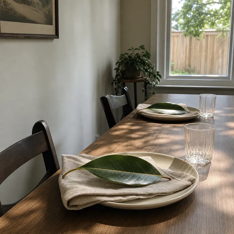 Neutral linen napkins and off-white plates are each accented with a single green leaf.