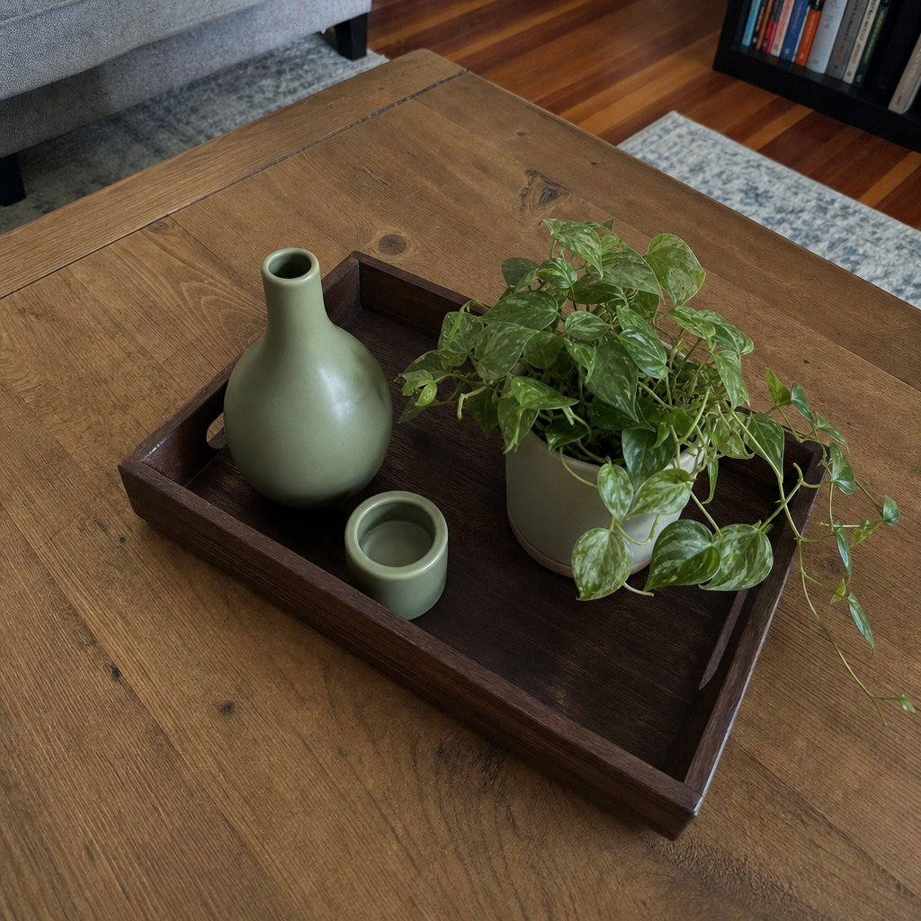 Brown tray with sage green decor on a coffee table.