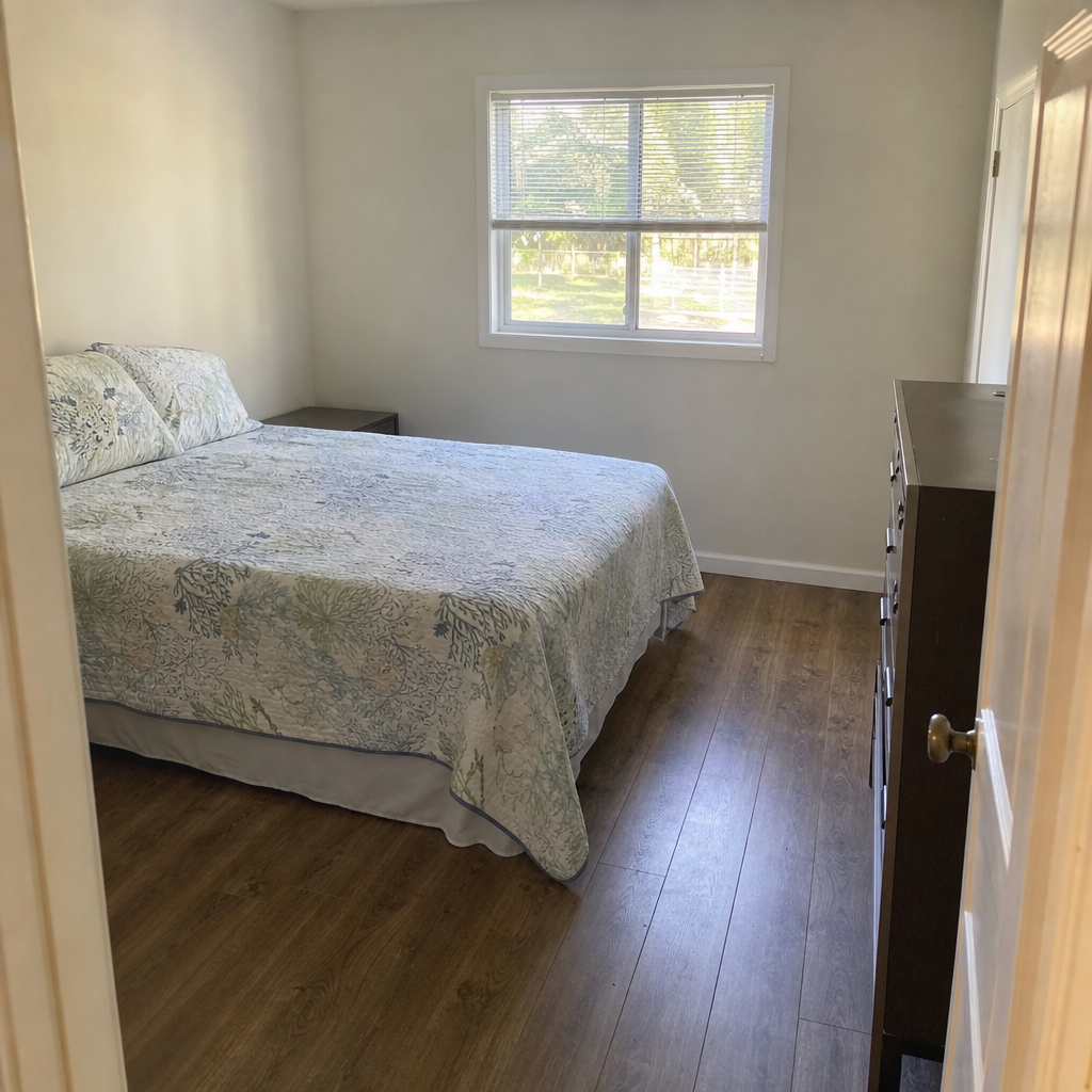 Small bedroom with a direct entry lane running beside a queen bed.